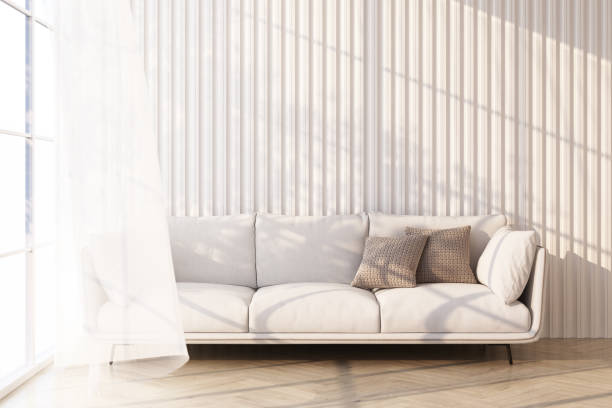 istock white sofa on wooden floor Light shines through the window and shadows fall on it. with white wall and sheer 3d rendering 1305666196