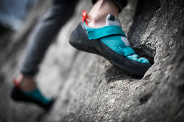 Person climbing while wearing rock climbing shoes Close up shot o a person climbing while wearing rock climbing shoes. rubber rocks stock pictures, royalty-free photos & images
