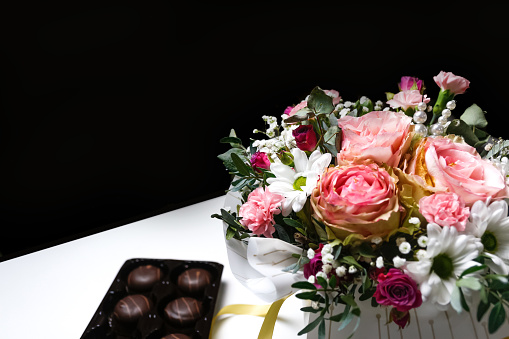 Flowers and chocolate. Flowers, bridal bouquet close-up. Decoration of roses, peonies and ornamental plants. Gift for Valentines day Women day. Mothers Day. White and black background selective focus.
