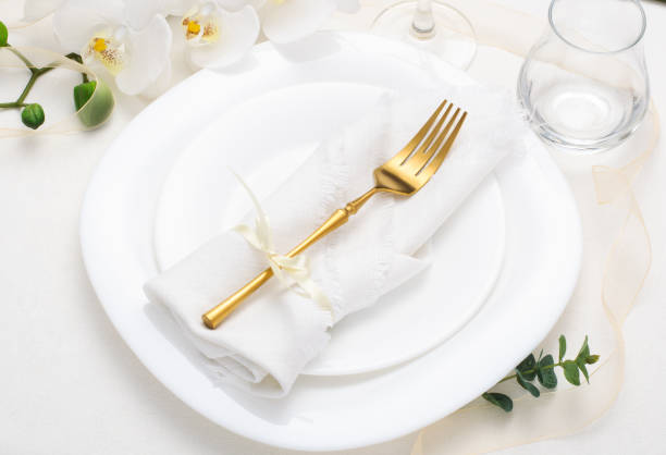 istock Spring, festive table setting with white napkin and white flowers on a light tablecloth 1305671404