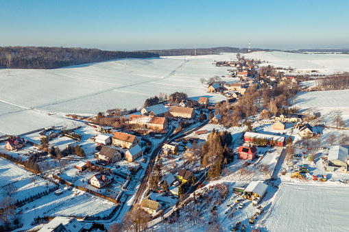 Aerial view of a village Stolec in Lower Silesian Voivodeship, in south-western Poland and snow-covered fields on the both sides of the village.