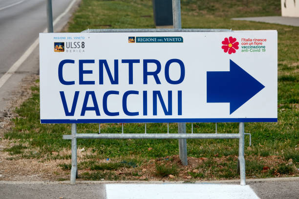 Arrow signpost with the inscription "Corona Covid-19 Vaccination Center" Italian Text Sign - fotografia de stock