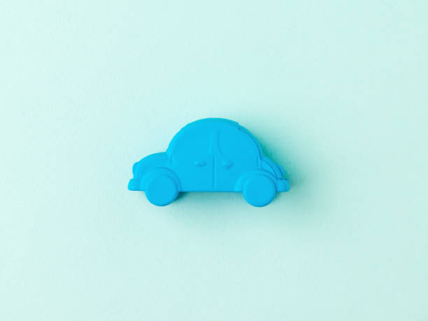 istock A small blue toy car on a light blue background. 1305676952