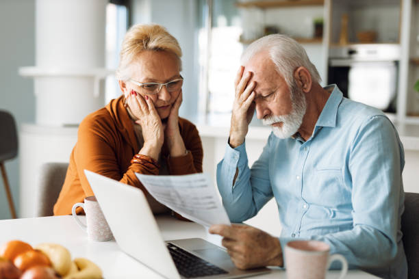 Frustrated mature couple having problems with paying their bills over Internet Worried senior couple feeling stressed while have to pay their bills over Internet worried stock pictures, royalty-free photos & images
