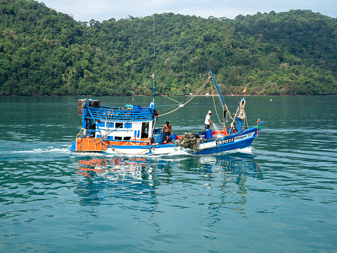 Trat, Thailand - March 1 2021; fishing boat moving in green blue sea island in Thailand