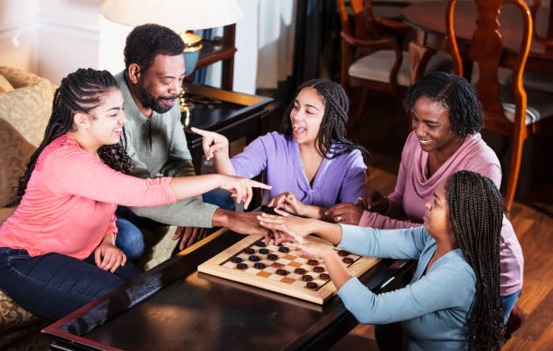 African-American family at home playing checkers