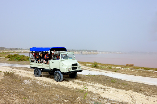 Dakar, Senegal - May 21,2012 : An ATV truck driving a load of tourist along the shore of Lake Retba, Lac Rose, used for salt mining by the local peoples.