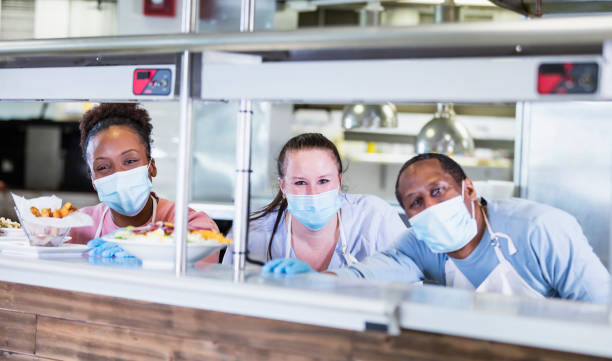 istock Workers in restaurant kitchen, wearing face masks 1305686583
