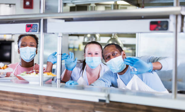 istock Workers in restaurant kitchen, wearing face masks 1305686601