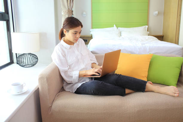 istock woman using laptop and lying to the sofa 1305686841