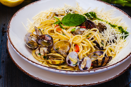 Italian food. Seafood pasta with clams. Spaghetti alle Vongole on white plate.