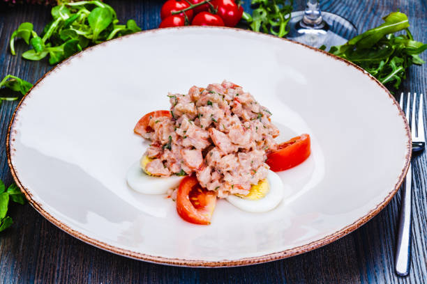 Lobster salad with egg and tomato on white plate.