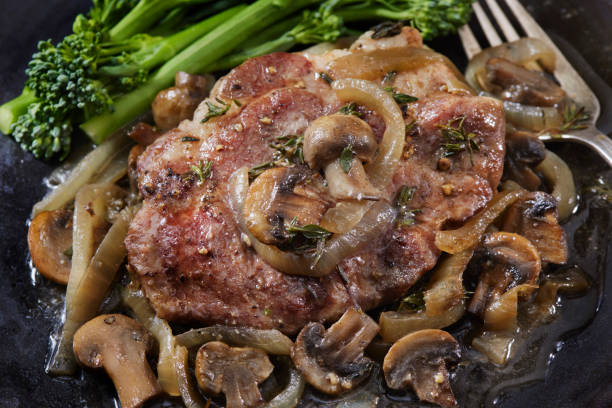 istock Pan Seared Pork Steak with Mushrooms, Onions and Broccoli 1305691509