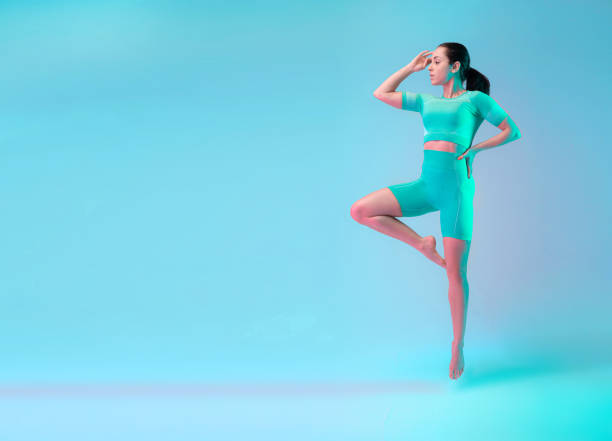 istock Graceful. Young sportive woman training isolated on gradient studio background in neon light. Modern sport, action, motion, youth concept. Beautiful caucasian woman practicing 1305692009