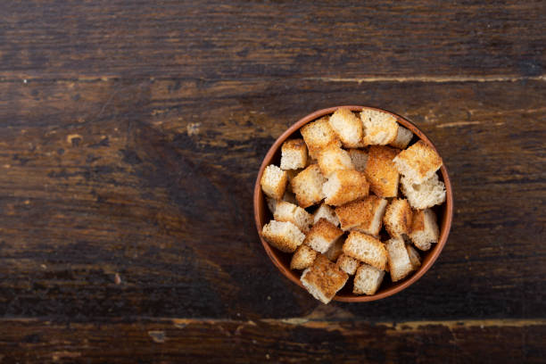istock Crispy croutons in a bowl on a wooden background. 1305693218