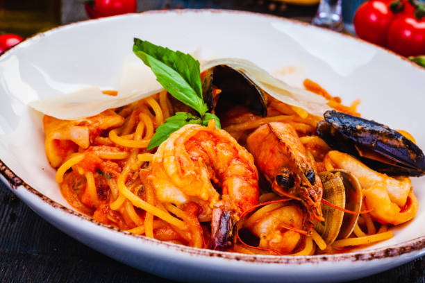 istock Pasta with seafood, tomato and parmesan cheese on white  plate 1305696146