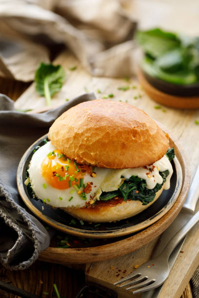 istock Vegetarian burger with fried egg and spinach sprinkled with chive served on a  plate 1305696343