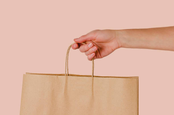 самка, держащая бумажный мешок - paper bag bag brown handle стоковые фото и изображения
