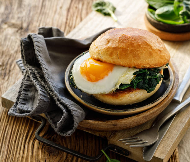istock Vegetarian burger with fried egg and spinach served on a plate 1305697504
