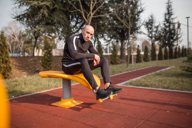 istock Young man taking a break after exercise at open gym 1305698071