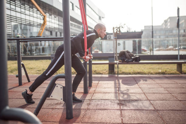 Young strong man in tracksuit exercising outdoors