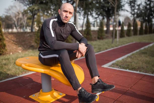 istock Young man resting after exercise at open gym 1305698486