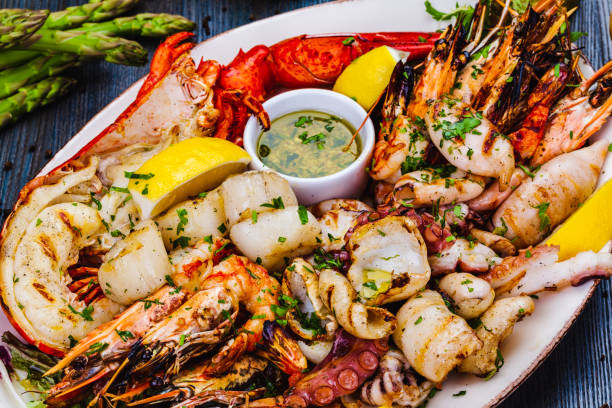 seafood platter. grilled lobster, shrimps, scallops, langoustines, octopus, squid on white plate. - prepared shrimp prawn seafood salad imagens e fotografias de stock