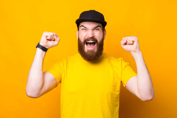istock Amazed bearded man screaming and celebrating victory over yellow background 1305700388