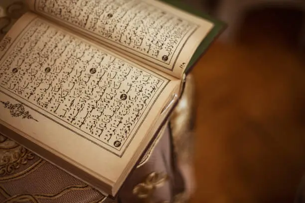 Directly above view of Quran with old pages standing on the table.