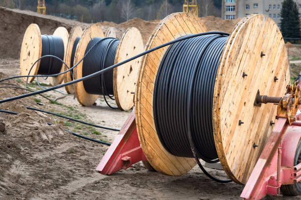 istock Concept of electricity supply for construction projects. Three wooden coils with power cable laid in trench. 1305710506