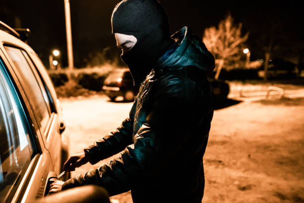istock Man with balaclava is going to steal car 1305714171