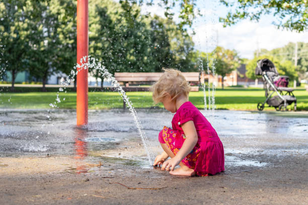 istock Little girl playing with splash pad in the park. 1305719018