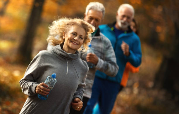 istock Group of mature folks jogging in a forest. 1305721803