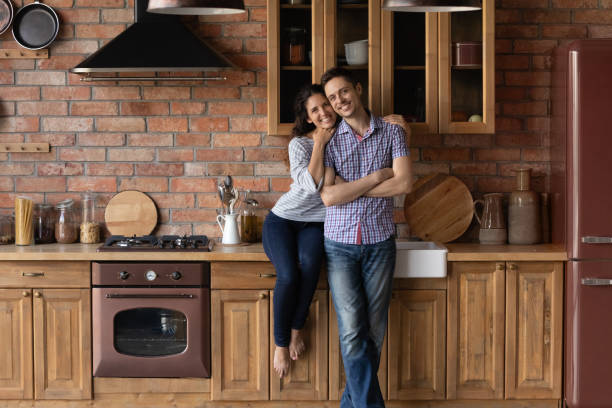 istock Full length portrait happy couple standing in modern kitchen 1305721842