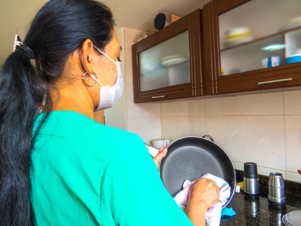 istock Housemaid drying the dishes with towel 1305724613