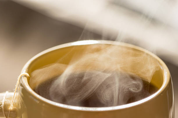 Steaming hot drink in cup close up view