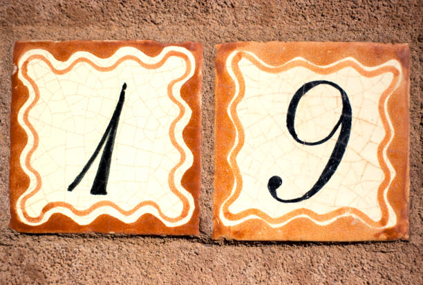 Ceramic Number 19 Street Address Tiles Ceramic Number 19 Street Address; Orange and white Mexican tiles on brown wall. ceramic tile house numbers stock pictures, royalty-free photos & images