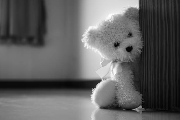 istock Broken heart, neglect, lonely with alone teddy bear sitting sad face next door. 1305736272