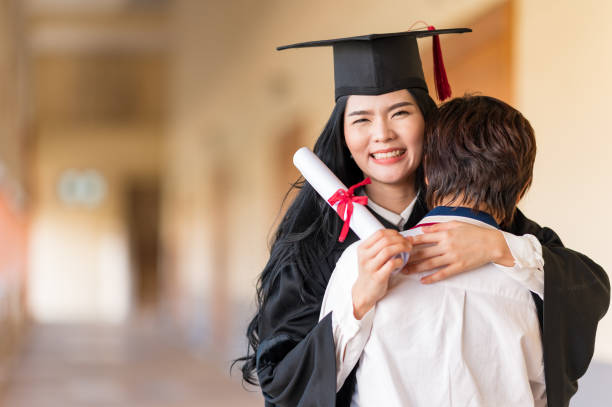 istock Happy student hugging her friend and celebrating her graduation 1305737863