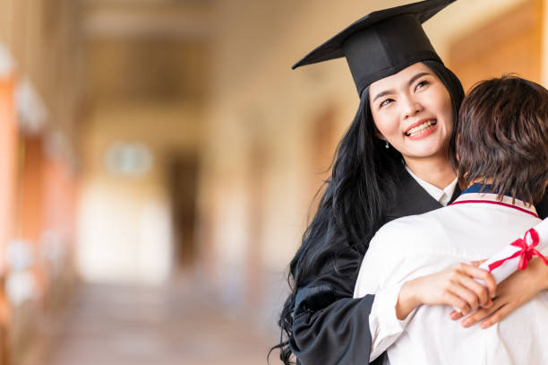 istock Happy student hugging her friend and celebrating her graduation 1305737873