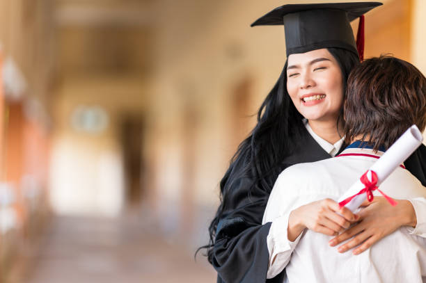 istock Happy student hugging her friend and celebrating her graduation 1305737874
