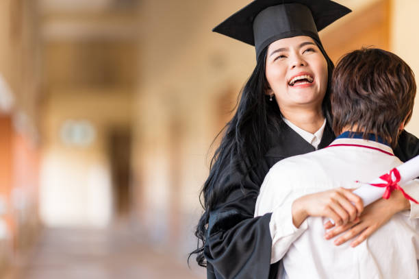 istock Happy student hugging her friend and celebrating her graduation 1305737912