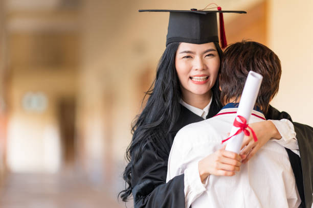 istock Happy student hugging her friend and celebrating her graduation 1305737920
