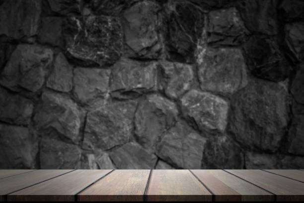 istock Empty room dark rock wall cover with floor cement  table. Gray black dark background. grey old rough wooden floor perspective interior. 1305745373