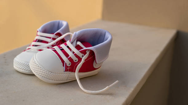 istock Baby shoes on blur outdoors background, closeup view 1305748900
