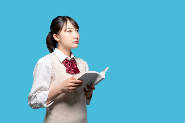 garota asiática do ensino médio lendo um livro. - aluna da escola secundária - fotografias e filmes do acervo
