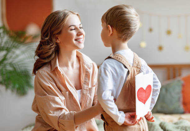 istock Boy making surprise for mother during holiday celebration 1305757791