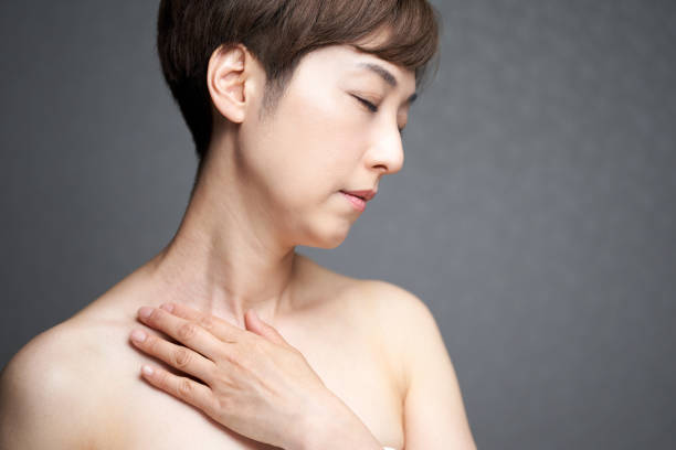 middle-aged japanese woman holding her shoulders - clavicle imagens e fotografias de stock