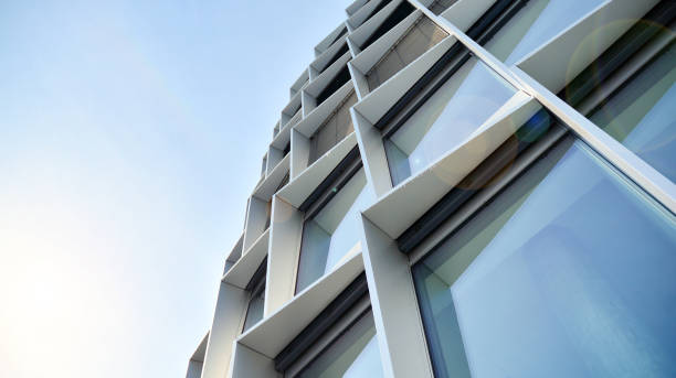 istock Modern architecture with sun ray. Glass facade on a bright sunny day with sunbeams on the blue sky. 1305771536