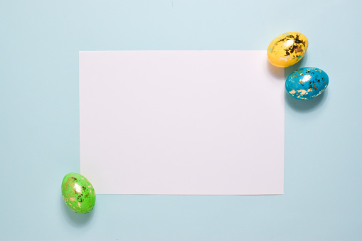 Five Easter eggs on a delicate background. Postcard with eggs on a light blue background. Layout for Easter. Invitation.